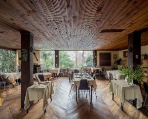 a dining room with tables and chairs and large windows at Hostería Millahue in San José de Maipo