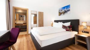 Pokój hotelowy z łóżkiem, biurkiem i umywalką w obiekcie Aparthotel Lerch w mieście Kappl