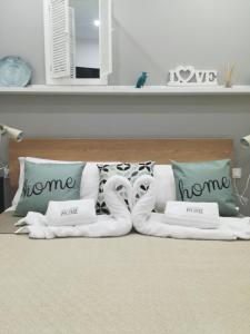 a white bed with pillows and a towel animal on it at Vacanze HOME in Caltanissetta