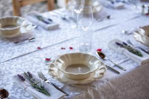 uma mesa com uma toalha de mesa branca com um prato e talheres em Provence Birtok em Decs