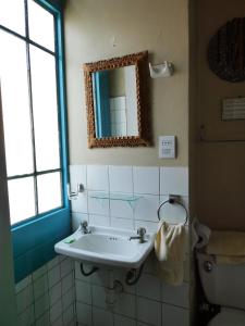 uma casa de banho com um lavatório, um espelho e um WC. em Park Hostel em Arequipa