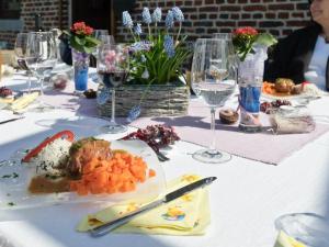 - une table avec une assiette de nourriture et des verres à vin dans l'établissement B&B Aux Gaietés de la Sabotière, à Seloignes