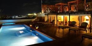 una piscina en la parte superior de un edificio por la noche en La Pasion Colonial Hotel Boutique By Bunik en Playa del Carmen
