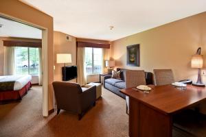 a hotel room with a bed and a living room at GrandStay Hotel & Suites La Crosse in La Crosse