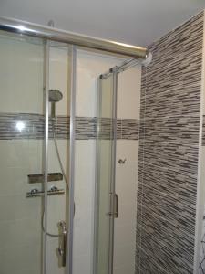 eine Dusche mit Glastür im Bad in der Unterkunft T2 confort,Vue d'Exception,calme,prés des pistes in La Mongie