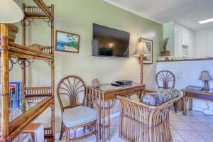 a living room with a desk and chairs at Mahina Surf 109 in Kahana