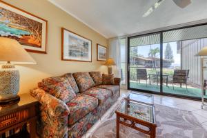 a living room with a couch and a glass table at Mahina Surf 109 in Kahana