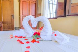 dos cisnes formando un corazón sobre una mesa con rosas en Casa Rural Rivero, en Posadas