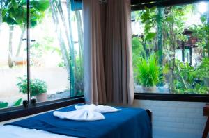 2 toallas en una cama en una habitación con ventana en Pousada Sonho de Geribá, en Búzios
