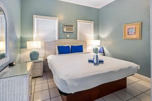 a bedroom with a large bed with blue pillows at Colors on White in Key West