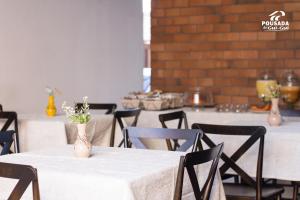 a table with chairs and vases with flowers on it at Pousada do Gui-Gui Aeroporto in Goiânia +35 photos