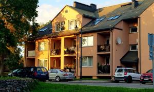 a building with cars parked in front of it at 2 kambarių apartamentai su virtuve, Trakų miesto centre in Trakai