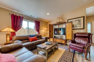 a living room with leather couches and a tv at The Captain's Quarters in Rockaway Beach