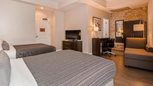 ein Hotelzimmer mit zwei Betten und einem Schreibtisch in der Unterkunft Best Western Plus St. Christopher Hotel in New Orleans + 59 Fotos