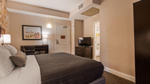 ein Hotelzimmer mit Bett, Schreibtisch und Fernseher in der Unterkunft Best Western Plus St. Christopher Hotel in New Orleans