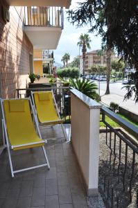 um par de cadeiras amarelas num pátio em VIALE REPUBBLICA 307 2 em Pietra Ligure