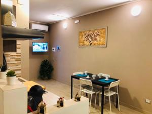comedor con mesa, sillas y TV en U Peri Alivu House, en Catania