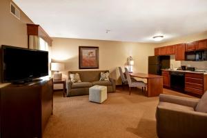 a living room with a flat screen tv and a kitchen at GrandStay Hotel & Suites La Crosse in La Crosse