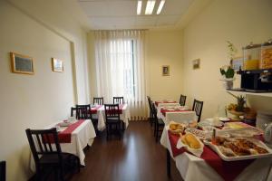 uma sala com mesas e cadeiras com comida em B&B Marbò Florence em Florença