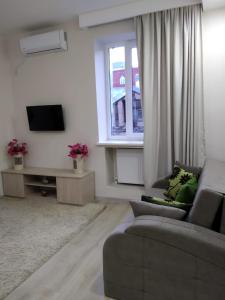 a living room with a couch and a tv at City Center Apartment in Tbilisi City