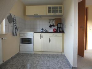 a small kitchen with white cabinets and a stove at Waldblick in Alt Schwerin