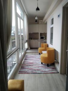 a living room with two yellow chairs and a kitchen at City Center Apartment in Tbilisi City