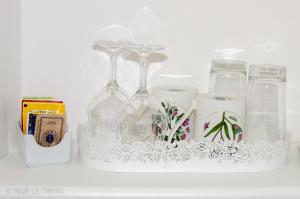 a shelf with several wine glasses and a bottle at Le Dimax in Sant'Agnello