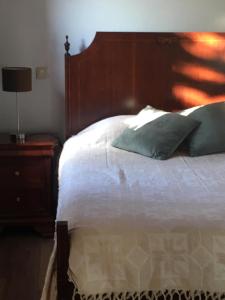ein Schlafzimmer mit einem Bett mit einem Kopfteil aus Holz in der Unterkunft Casa do Tuga in Bragança