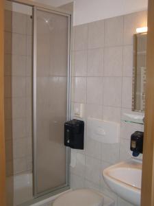 y baño con ducha, aseo y lavamanos. en Hotel Alt Vinnhorst en Hannover