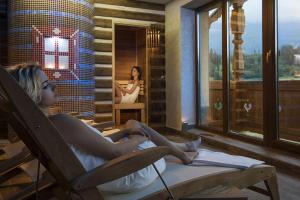 a girl sitting in a chair in a room with a mirror at Wellness Penzion Strachan in Ždiar