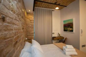 - une chambre avec un lit et un mur en pierre dans l'établissement AL 54 Accommodation, à San Benedetto del Tronto