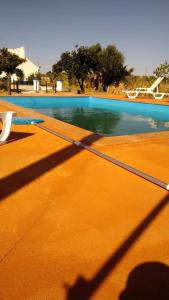une ombre d'une personne debout à côté d'une piscine dans l'établissement Reguengos Hotel, à Reguengos de Monsaraz