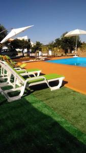 a group of lawn chairs sitting next to a pool at Reguengos Hotel in Reguengos de Monsaraz