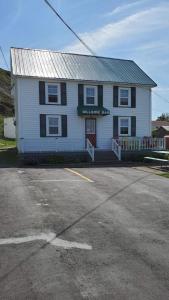 a white house with a parking lot in front of it at Hillside B&B in Twillingate