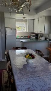 una cocina con una mesa con un bol de fruta. en Hillside B&B, en Twillingate