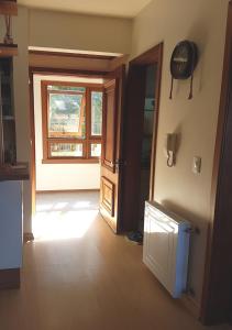 un pasillo con una puerta y una ventana en una casa en Belo apartamento e completo no Centro com vista, en Gramado