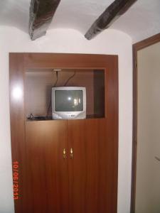 un televisor sentado en la parte superior de un armario de madera en Pensión Santa Marta, en Calatayud
