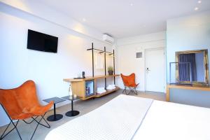 a bedroom with a bed and two orange chairs at Basilico in Gouves