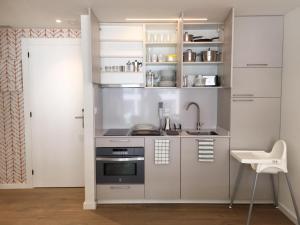 a small kitchen with a stove and a sink at Casas Á Beira - Apartamentos in Pontevedra