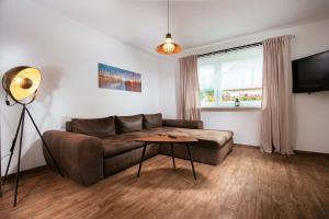 a living room with a couch and a table at Landhaus Kranichgrund in Lüdershagen