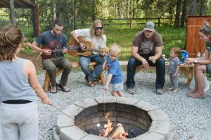 a group of people sitting around a fire pit at Under Canvas Glacier in Coram