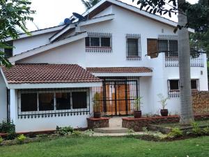 a white house with black windows and a yard at Darrel House in Kisumu