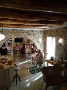 um grupo de pessoas sentadas em mesas em um restaurante em La Casa della Filanda em Belmonte Calabro
