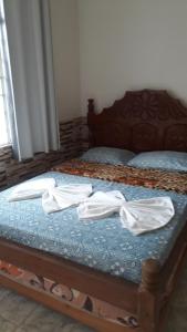 a bed with two white towels sitting on it at Pousada Casa Branca in Salinópolis