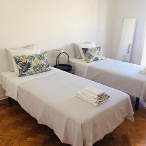 two beds with towels on top of them in a room at AL CASA GRANDE in Olhão