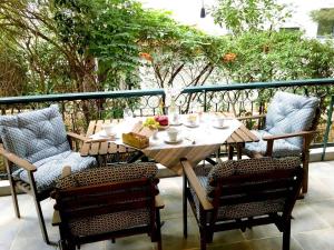 アテネにあるA2 Cute Vouliagmeni Apt in a Unique Spotの木製テーブルと椅子、バルコニーで食事を楽しめます。