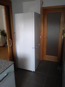- un réfrigérateur blanc dans une cuisine à côté d'une porte dans l'établissement Teleña, à Cangas de Onís