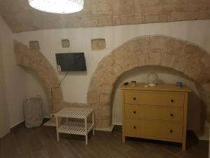 a room with a dresser and a tv in a room at Casa Arco della Chicca in Monopoli