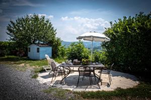 a table and chairs with an umbrella in a yard at CASA RAMAGIO' in La Morra