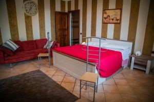 a bedroom with a bed and a red couch at CASA RAMAGIO' in La Morra